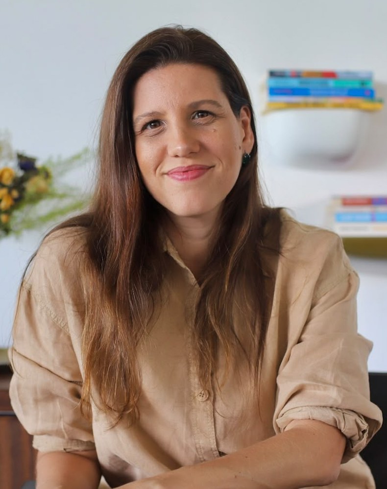 Priscilla Fontes, psicóloga clínica, sorrindo em seu consultório